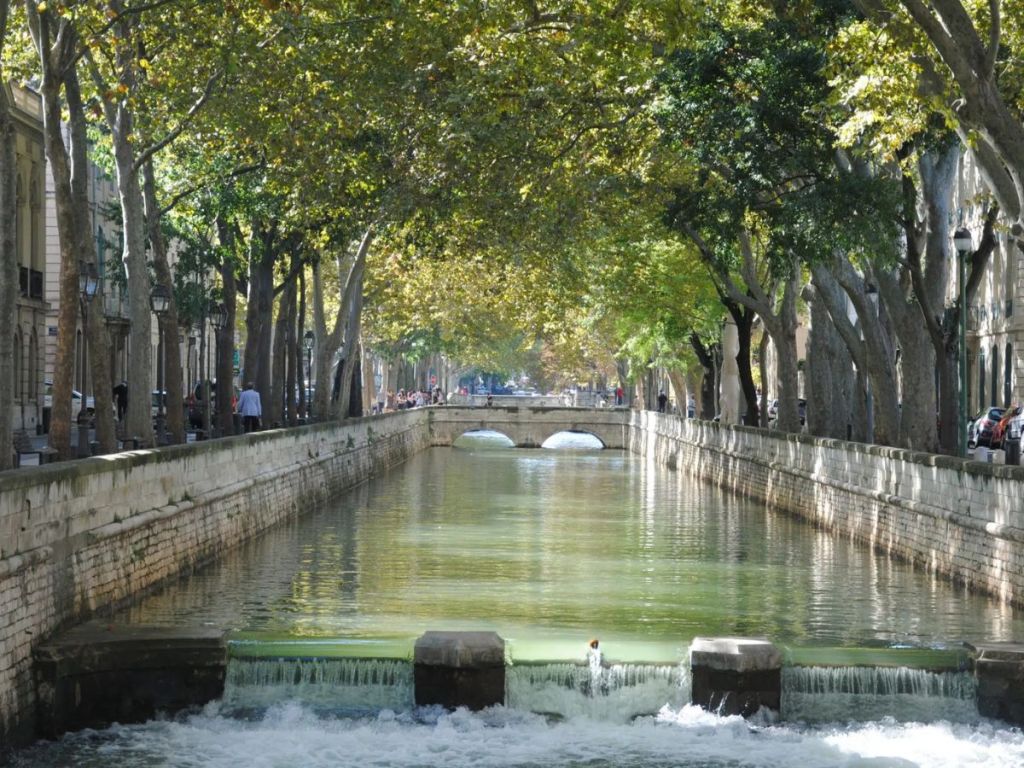 Canal de la Fontaine in Nîmes, tree-lined urban canal flowing through the city 