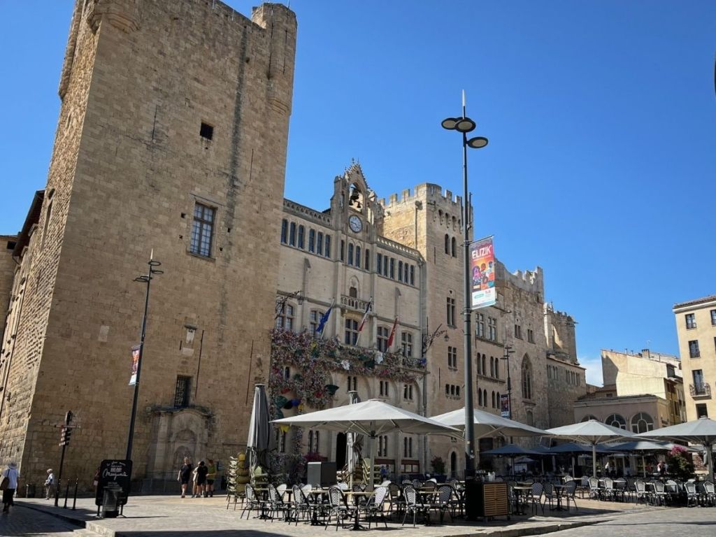 Panoramic view of the Place de l'Hôtel de Ville in Narbonne, with the Gilles Aycelin keep, Archbishop's Palace and café terraces