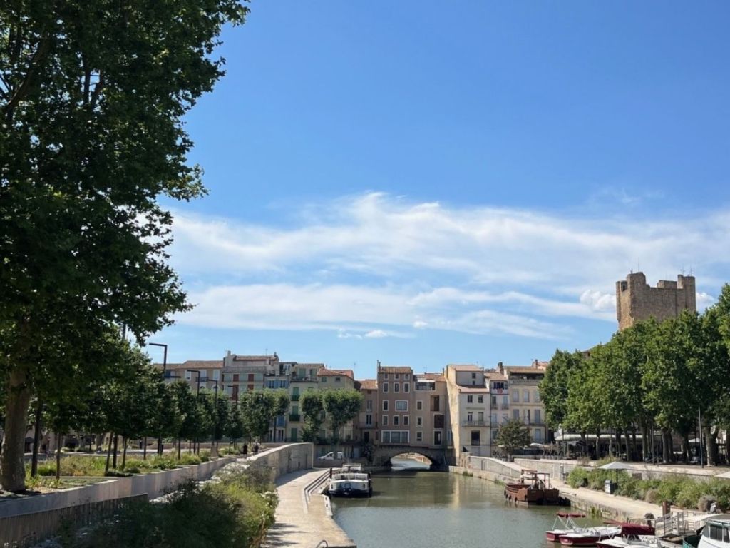 The Robine Canal in Narbonne with the Gilles Aycelin keep in the background and the inhabited Pont des Marchands spanning the water