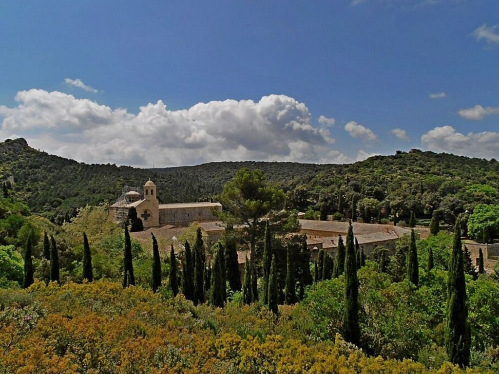 Fontfroide Abbey nestled among cypress trees and Mediterranean scrubland in the Aude countryside