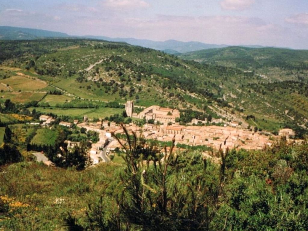 Aerial view of Lagrasse village and its abbey surrounded by hills in the Aude countryside