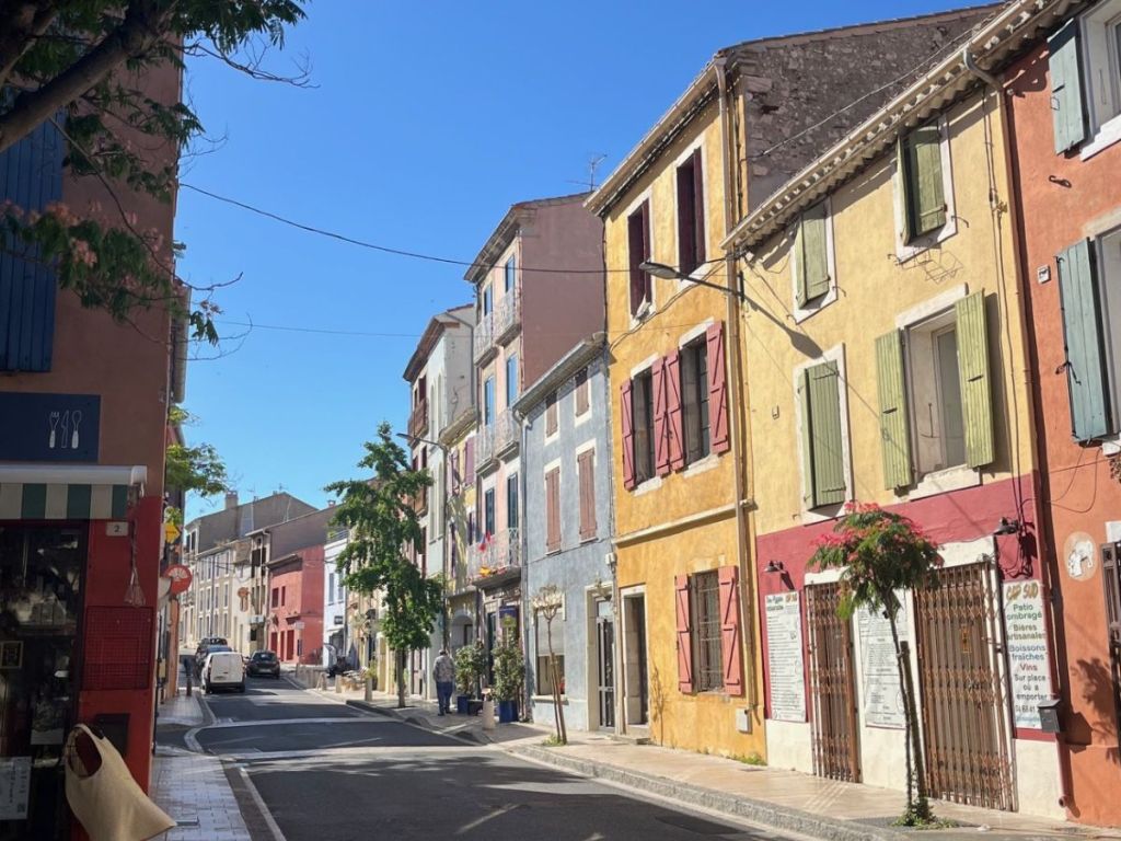Colorful house façades on a narrow street in the old village of Leucate